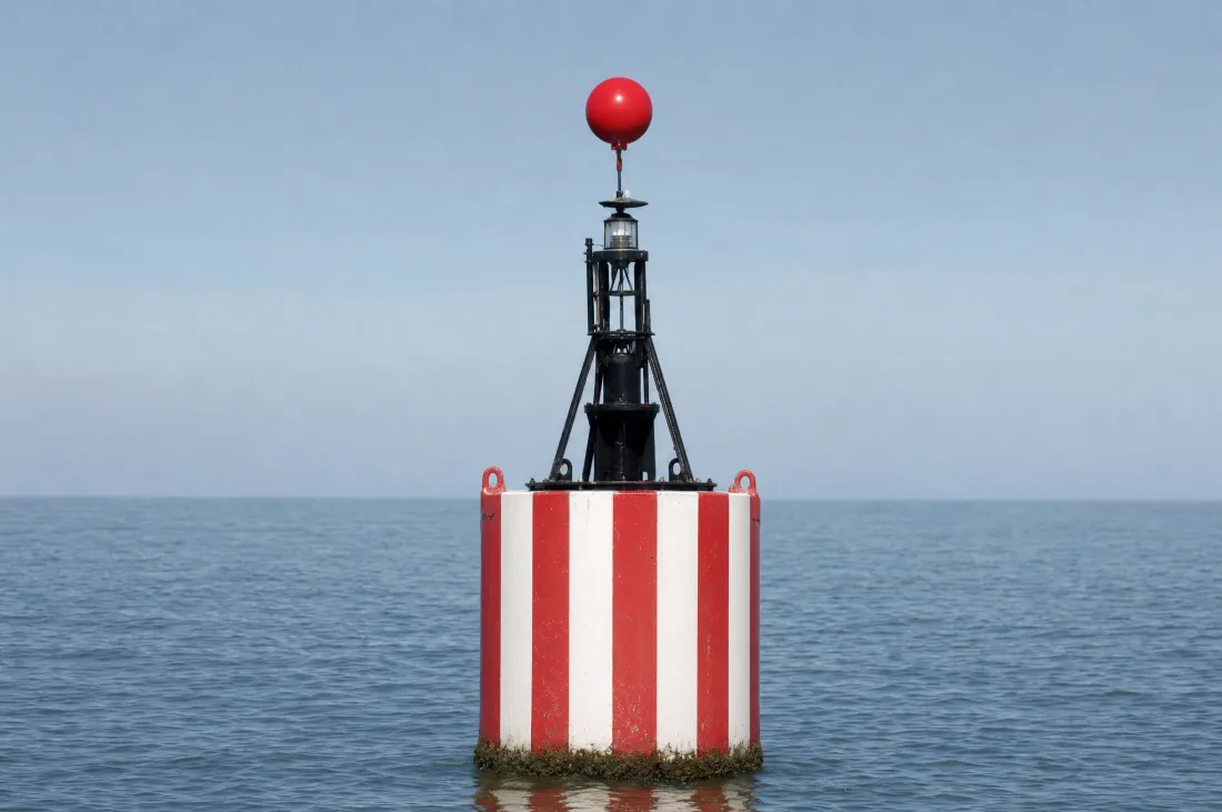 Mittefahrwasserzeichen: rot und weiß senkrecht gestreifte Tonne mit einem roten Ball als Toppzeichen